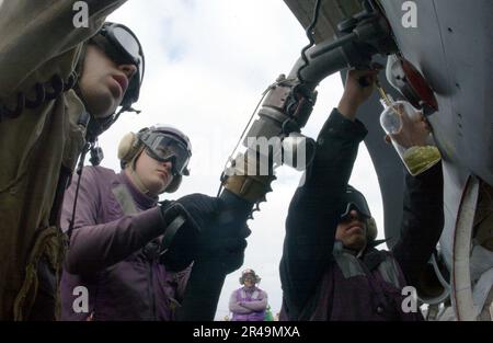 I marinai della Marina STATUNITENSE assegnati alla divisione USS Carl Vinson (CVN 70) del reparto aereo V-4 prelevano un campione di carburante durante le operazioni di rifornimento di velivoli sul ponte di battaglia della nave Foto Stock