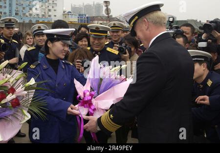 ROBERT Willard, Comandante USA Settima flotta, riceve un tradizionale saluto di fiori da un rappresentante dell'Esercito popolare di Liberazione (Marina) Foto Stock