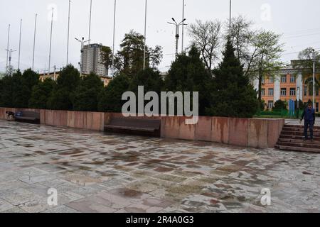 Un parco pubblico panoramico in una giornata nuvolosa con diverse persone che camminano per godersi l'aria fresca e la natura Foto Stock