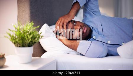 Giovane africano affetti da febbre giacente sul letto Foto Stock