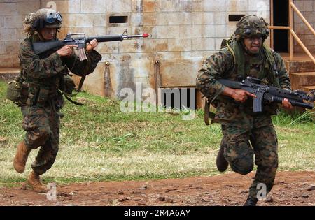 US Navy Marines, assegnato a 3rd battaglione, 3rd Marine Regiment, India Company, manovrare rapidamente attraverso una strada per guadagnare una posizione migliore da cui combattere Foto Stock