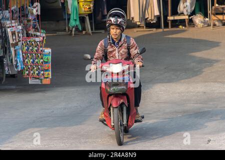 SAMUT PRAKAN, THAILANDIA, MAR 03 2023, Un uomo con casco cavalca una moto Foto Stock