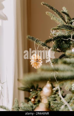 Una scena festosa di festa con un lussureggiante pino verde adornato con ornamenti natalizi Foto Stock