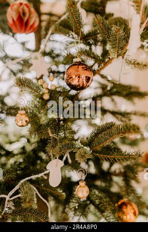 Una scena festosa di festa con un lussureggiante pino verde adornato con ornamenti natalizi Foto Stock