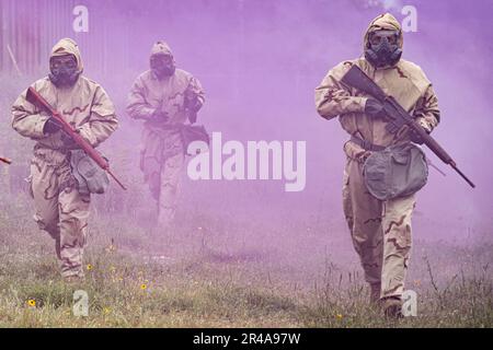 I soldati che indossano l'attrezzatura MOPP (Mission Oriented Protective Posture) corrono in un sito di test a Camp Bullis, Texas. Hanno partecipato al test del sistema anticonvulsivo avanzato, Rafa midazolam Auto-Injector (Rafa ai). Il test è stato organizzato dagli Stati Uniti Army Medical Center of Excellence Medical Test and Evaluation Activity per condurre una valutazione dei fattori umani dell'efficacia del Rafa ai e se il dispositivo soddisfa gli standard stabiliti dal Joint Program Executive Office - Chemical, Biological, Radiological, Nuclear Defense. Foto Stock