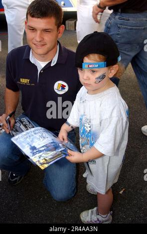 IL pilota NASCAR della Marina STATUNITENSE Casey Atwood firma una foto per un giovane appassionato di corse al dover International Speedway di Delaware Foto Stock