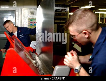 US Navy Aviation Electronics Technician 1st Class Left, insegna Aviation Electronics Technician Airman Right, come piegare le lamiere nell'officina Foto Stock