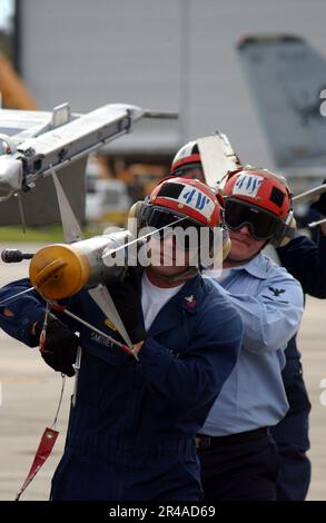 US Navy Aviation Ordnancemen rimuovere un missile AIM-9M Sidewinder da un F-A-18A- Hornet Foto Stock