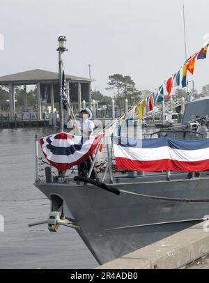 US NAVY A U.S. Coast Guardsman alza l'Union Jack sulla prua dell'imbarcazione di pattuglia della Guardia Costiera USCGC Shamal (WPC 13) Foto Stock