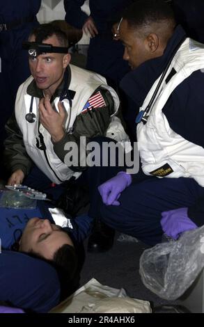 US Navy Senior Medical Officer, CMdR. John Burgess di Goldsboro, N.C., allena i membri dell'equipaggio sulle procedure di pronto soccorso durante una trivella per incidenti di massa Foto Stock