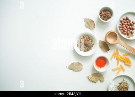 Un'immagine di una serie di piccole ciotole bianche, ciascuna riempita con verdure e spezie diverse, disposte in una pila multistrato Foto Stock