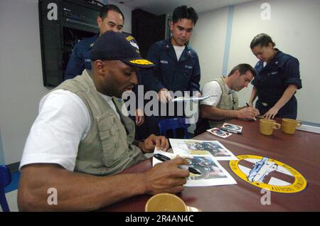 US Navy New York Giants ampio ricevitore Amani Toomer, primo piano, e quarto di schiena Kurt Warner firma autografi per i marinai stazionati a bordo della nave militare Sealift Command (MSC) ospedale USNS Mercy (T-AH 19) Foto Stock