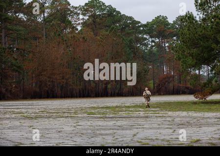 NEGLI STATI UNITI Marine Corps Recruit da Hotel Company, 2nd reclutamento addestramento battaglione, vaga attraverso il terreno durante il corso di navigazione terrestre sul Marine Corps Recruit Depot Parris Island, South Carolina, 28 marzo 2023. Durante il corso, le reclute hanno dovuto navigare in vari punti di una mappa utilizzando una bussola. Foto Stock