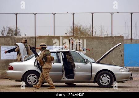 US Navy U.S.A. Marines e marinai, assegnati a 1st Divisione Marina, 2nd Battaglione, 5th Marines, cercano veicoli iracheni e loro occupanti a un Ramadi, Iraq checkpoint Foto Stock