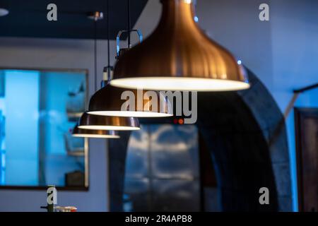 Moderno ristorante interno cucina con diverse lampade eleganti che illuminano lo spazio Foto Stock