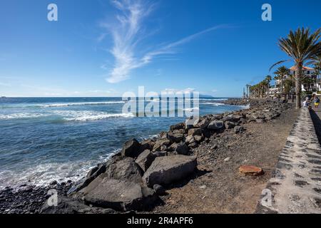 Una spiaggia tropicale caratterizzata da palme ondeggianti, rocce levigate e onde ondulate Foto Stock