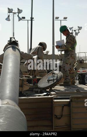 US Navy Operations Specialist 2nd Class ispeziona un ente statunitense Esercito M1A1 Abrams principale serbatoio di battaglia per gli Stati Uniti Battaglione di ispezione doganale della Marina a Camp Arifjan, Kuwait. Foto Stock