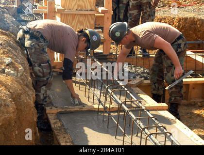 US Navy Builder 3rd Class Left e Steelworker 3rd Class utilizzano un galleggiante in magnesio per livellare il calcestruzzo. Foto Stock