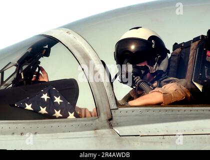 US Navy un pilota F-A-18F Super Hornet, assegnato al Black Knights of Strike Fighter Squadron One Five Four (VFA-154), attende con Old Glory il suo turno per essere lanciato fuori dal ponte di volo a bordo di USS Carl VI. Foto Stock