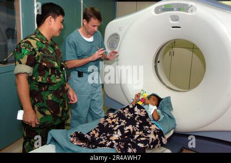 US Navy Lt. CMdR. Right, e il Capt. Militare indonesiano discutono di un paziente indonesiano preparato per una scansione di tomografia assiale computerizzata (CAT, Computed Axial Tomography). Foto Stock