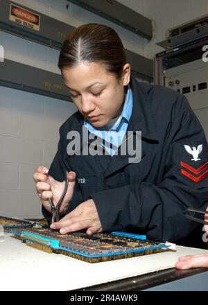 US Navy Aviation Electronics Technician 2nd Class dimostra come riparare un componente allentato in un interruttore automatico. Foto Stock