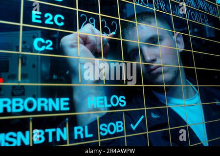 US Navy Air Traffic Controller 3rd Class scrive lo stato di ciascun aeromobile sulla scheda di stato del Carrier Air Traffic Controller Center (CATCC) a bordo della USS John F Kennedy (CV 67) durante il volo. Foto Stock