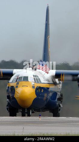 US Navy Membro dell'equipaggio a bordo degli Stati Uniti Corpo marino C-130 Hercules Fat Albert, assegnato agli Stati Uniti Il team di dimostrazione dei voli Navy Blue Angels, sfoggia con orgoglio una bandiera americana mentre tassava. Foto Stock