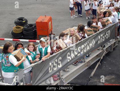 US Navy Girl Scouts e Brownies da due truppe a Singapore passare Girl Scout cookie Box sulla fronte della nave di salvataggio USS Safeguard (ARS 50) come parte dell'operazione Thin Mint. Foto Stock