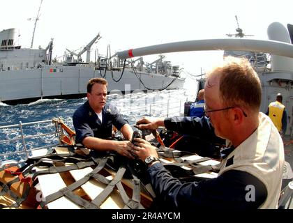 US Navy Fire Controlman 1st Class e Boatswain Mate 2nd Class assegnati all'incrociatore missilistico guidato di classe Ticonderoga USS Normandy (CG 60) avvolgono i pallet di carico Foto Stock