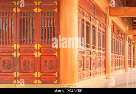 Una vista esterna di un tipico edificio Cinese caratterizzato da un corridoio con porte in legno Foto Stock