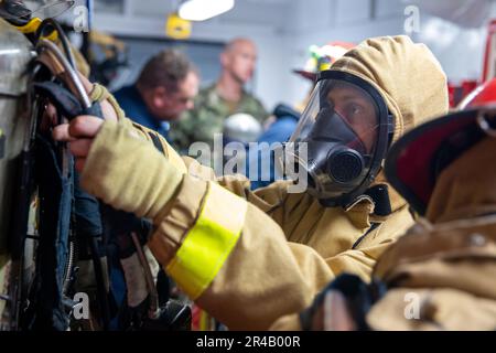 APRA HARBOR, Guam (9 gennaio 2023)—Hull Maintenance Technician Third Class Zachary Jacobsen, assegnato al sottomarino USS Emory S. Land (COME 39), allena un complesso antincendio durante un'esercitazione antincendio a tutte le mani a bordo della nave, il 9 gennaio. Emory S. Land ha il compito di fornire servizi di manutenzione e riparazione di livello intermedio, nonché di fornire servizi alberghieri e supporto logistico ai sottomarini guidati-missili e ad attacco rapido. Foto Stock