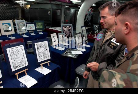 US Navy Storekeeper 2nd Classe destra, fornisce la USS Ronald Reagan (CVN 76) Senior Medical Officer, CMdR. con una certa comprensione nella sua illustrazione comic di stile del libro. Foto Stock