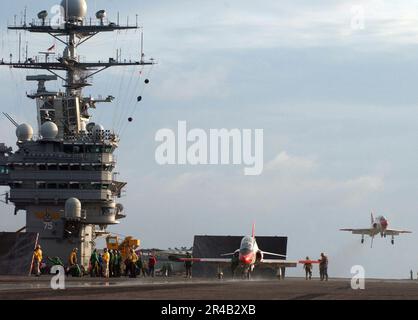 US Navy Un velivolo allenatore T-45A Goshawk, assegnato all'addestramento Air Wing Two (TW-2), si prepara al lancio, mentre un altro tira verso il cielo dopo aver fatto sventolare il suo recupero arrestato. Foto Stock