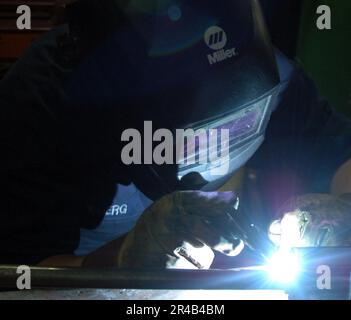 US Navy Hull Maintenance Technician Fireman salda insieme le tubazioni nell'officina a bordo della portaerei di classe Nimitz USS Harry S. Truman (CVN 75). Foto Stock