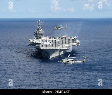 US Navy due elicotteri Seahawk HH-60H sorvolano di fronte la portaerei di classe Nimitz USS Theodore Roosevelt (CVN 71). Foto Stock