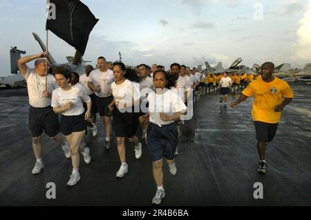 I selectees di US Navy Chief Petty Officer (CPO) corrono in formazione con il Mess di Chief Petty Officer sul ponte di volo a bordo della portaerei a propulsione convenzionale USS Kitty Hawk (CV 63). Foto Stock