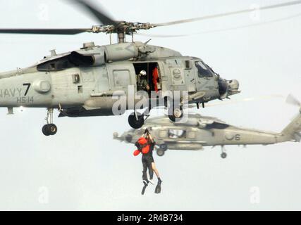 US Navy U.S.A. Tecnologia Air Force. SGT. È issato a bordo di un U.S.A. Navy HH-60H elicottero Seahawk Foto Stock