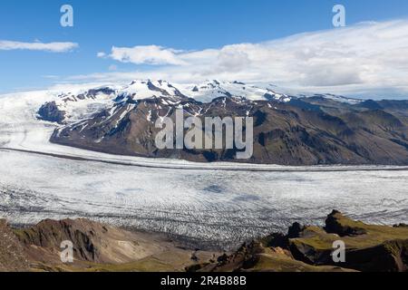 Fiume glaciale Skaftafellsjokull che scorre lungo la montagna vulcanica. Islanda meridionale. Vista aerea dalla cima del monte Kristinartindar. Foto Stock