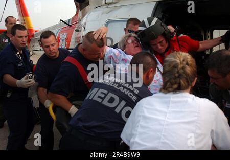 US NAVY A U.S. Coast Guard elicottero di salvataggio equipaggio e paramedici della zona Mobile, Ala., assistere un sopravvissuto uragano Katrina su un gurney presso la base della Mobile Coast Guard. Foto Stock