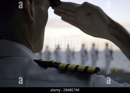 US Navy USS Abraham Lincoln (CVN 72) Comanding Officer, Capt. Rende onore durante una sepoltura in mare a bordo della portaerei della classe Nimitz. Foto Stock