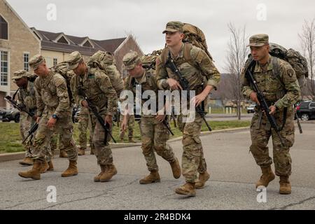 I soldati della Guardia Nazionale di New York che gareggiano nel Concorso del miglior Guerriero dello Stato del 2023 decollano dalla linea di partenza di un ruck di 12 miglia a Camp Smith, N.Y., 5 aprile 2023. La marcia del ruck è stata l'evento fisico culminante del concorso di più giorni, che ha riunito guardiani da tutto lo stato di New York. Foto Stock