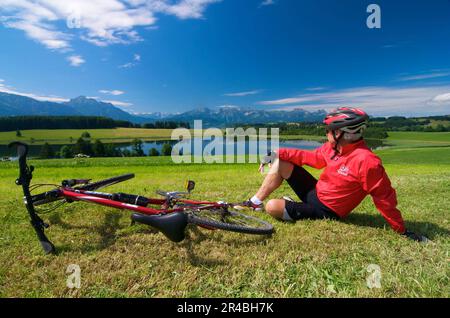 Ciclista, Forggensee, Allgaeu, Baviera, Germania Foto Stock