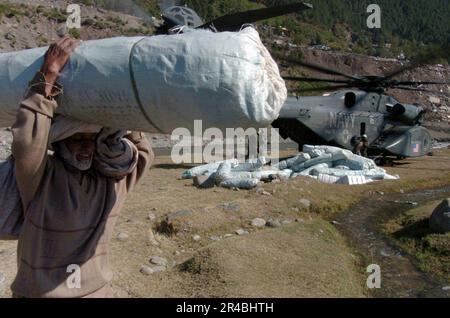 US Navy un anziano pakistano uomo porta una tenda lontano da un US Navy MH-53 Sea Dragon elicottero. Foto Stock