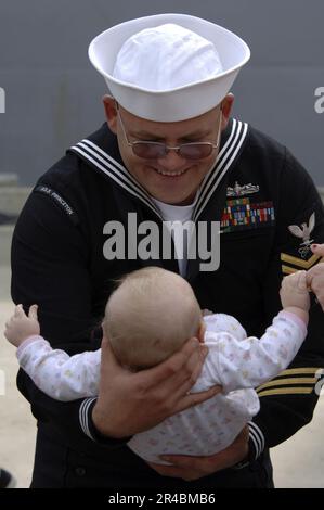 US Navy Electrician's Mate 1st Class tiene la sua bambina di sei mesi dopo essere ritornata a casa da un dispiegamento regolare di sei mesi a bordo dell'incrociatore missilistico guidato USS Princeton ( Foto Stock