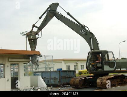 US Navy Equipment Operator 2nd Classe assegnata a Naval Mobile Construction Battalion Four (NMCB-4) Alfa Company gestisce un escavatore durante la demolizione di una capanna di protezione smantellata. Foto Stock