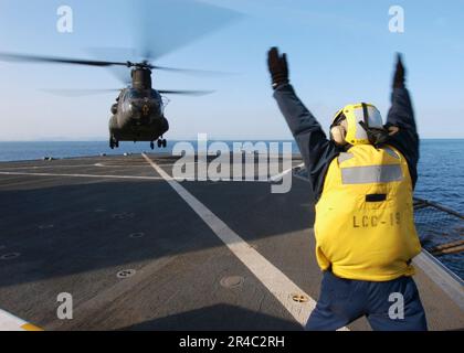 US Navy Boatswain's Mate 2nd Class segnala ad un elicottero dell'esercito CH-47 Chinook assegnato al 52nd Aviation Regiment Camp da Humphreys Korea. Foto Stock