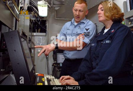 US Navy Information Systems Technician 1st Class Trains Information Systems Technician 2nd Class sull'uso del sistema di sicurezza delle informazioni (INFOSEC) Foto Stock