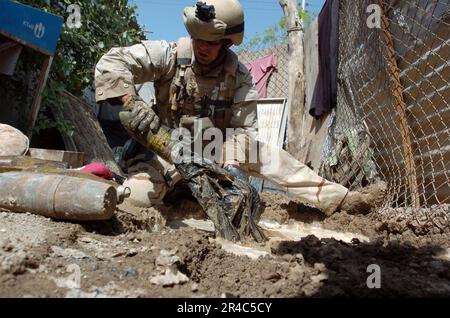 US Navy U.S.A. Navy Hull Technician 2nd Classe assegnata all'unità mobile 6 di smaltimento delle ordigni esplosive (EODMU-6), distaccamento 10, recupera l'ordigni sepolti alla vista di un edificio abbandonato. Foto Stock