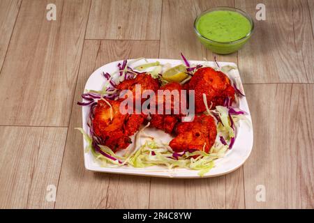 tikka di pollo o kebab di pollo in piatto su sfondo di legno Foto Stock