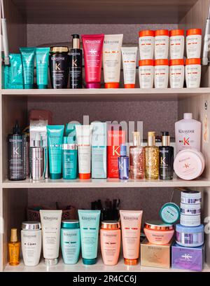 Molti vasetti diversi di shampoo, balsami per la cura dei capelli sullo scaffale. Vasetti e provette sono in fila Foto Stock